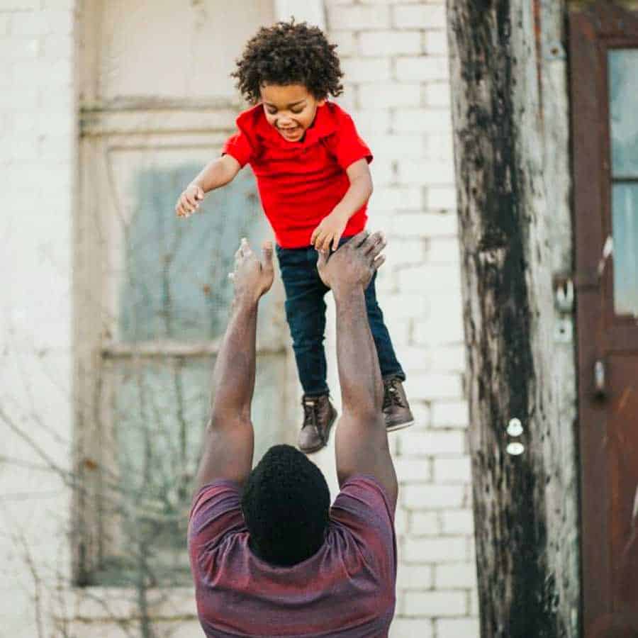man throwing son in air